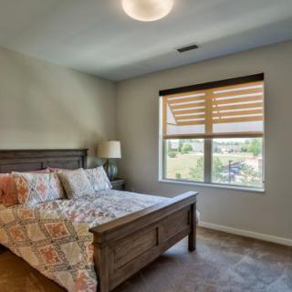 A cozy bedroom with a large window and stylish furnishings.