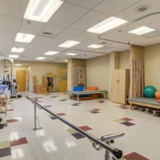 A spacious rehabilitation room equipped with physical therapy and exercise equipment.