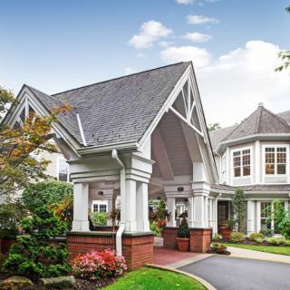 A picturesque residential house with a grand entrance and well-maintained garden.