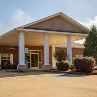 A building with a columned entrance and surrounding landscaping.