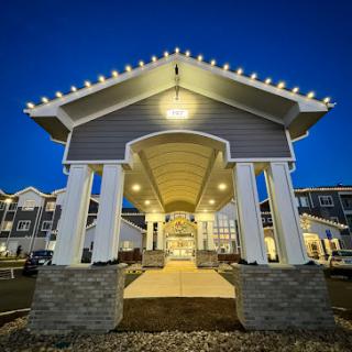 A beautifully lit entrance of a modern building at night, showcasing elegant architectural features.