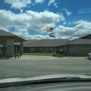 A view of a building with flags flying under a partly cloudy sky.