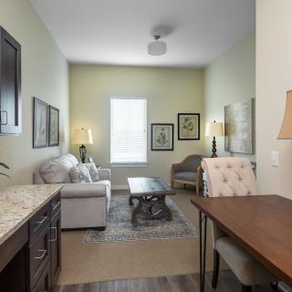 A cozy living room with a sofa, coffee table, desk, and stylish decor.