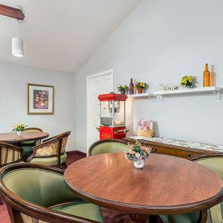 A cozy dining area featuring round tables, comfortable chairs, and a popcorn machine for added charm.
