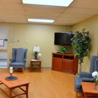 A cozy waiting room with comfortable seating, a television, and decorative elements.
