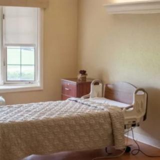 A clean and tidy hospital room with a bed and window.