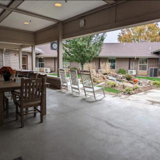 A cozy outdoor patio with rocking chairs, overlooking a well-maintained garden.