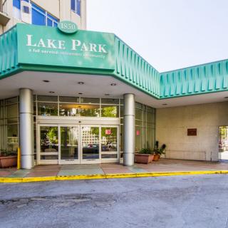 Entrance to the Lake Park Hotel with a green awning and glass doors.