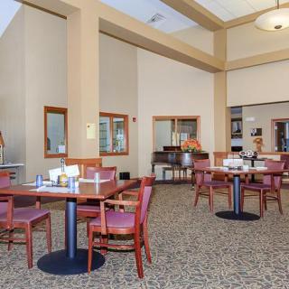 A spacious dining area with neatly arranged tables and chairs, featuring a carpeted floor and elegant interior decor.