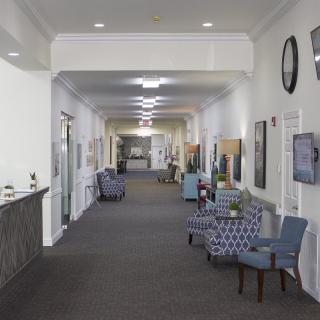 A well-lit hallway featuring comfortable seating and decorative elements.