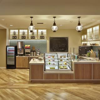 A modern cafe interior with a display counter and beverage options.