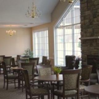 A spacious dining area featuring elegant chandeliers, large windows, and neatly arranged tables and chairs.