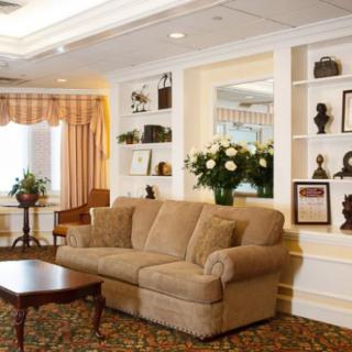A cozy living room with a sofa, coffee table, and decorative shelves.
