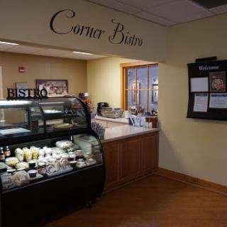 A cozy corner bistro featuring a food display and a welcoming atmosphere.