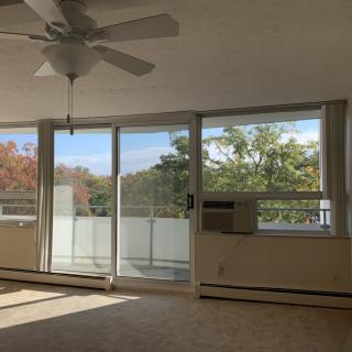 Bright living room with large windows and a view of the balcony.