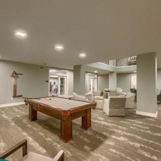 A modern recreation room featuring a pool table and comfortable seating area.