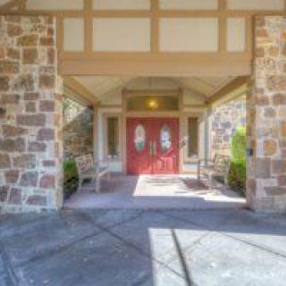A building entrance with stone walls and bright red doors.