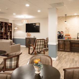 A cozy lounge area with seating, a coffee station, and a TV.