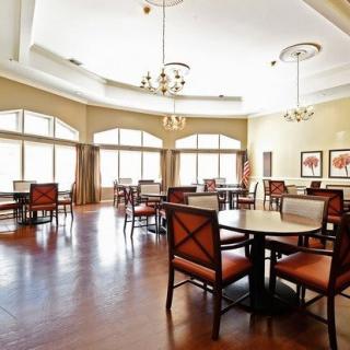 A bright and spacious dining room with elegant furniture and large windows.