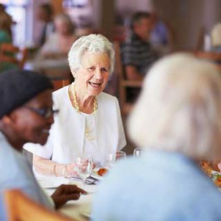 A group of seniors enjoying a meal together in a community setting.
