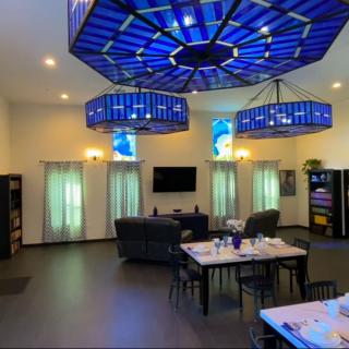 A modern room with striking blue ceiling lights and a dining area.