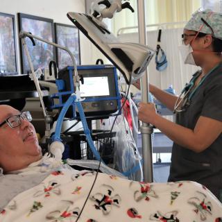 A healthcare professional assists a patient in a hospital setting.