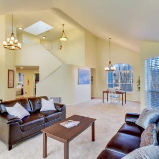 A spacious and bright living room with modern furniture and high ceilings.