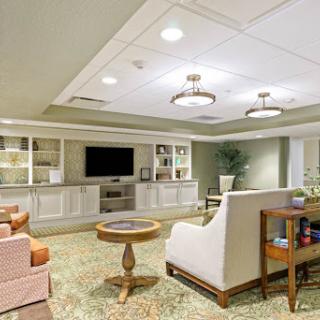 A cozy and modern lounge area featuring comfortable seating, a television, and warm lighting.