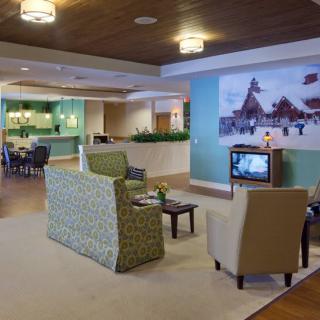 A modern lobby area with comfortable seating and a television near the reception desk.