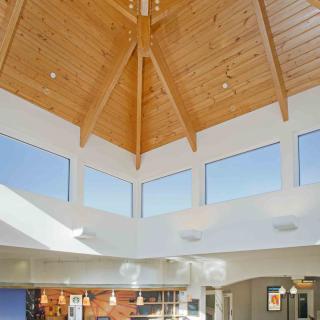 A bright and spacious modern interior with a high wooden ceiling and ample natural light.