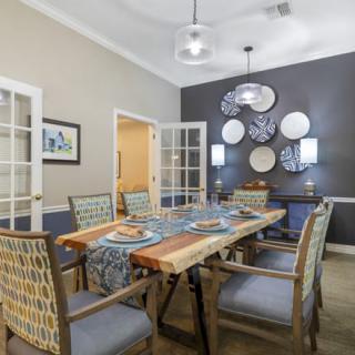 A modern dining room featuring a wooden table, stylish chairs, and decorative wall art.