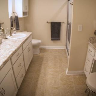 A modern and spacious bathroom featuring a marble countertop, a clean sink area, and neutral tones.