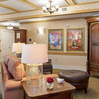 A cozy living room with comfortable seating, decorative artwork, and warm lighting.