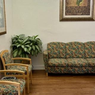 A cozy waiting room with patterned seating and framed artwork.