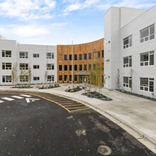 A modern building with a curved design and numerous windows, captured during the daytime.
