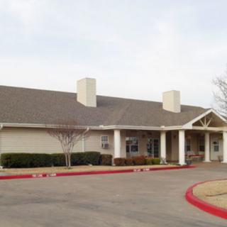 A single-story building with a wide roof and white pillars at the entrance.