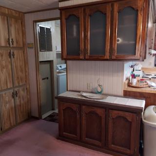 A view of a vintage kitchen featuring wooden cabinets and essential appliances.