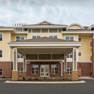 A modern multi-story building with a central entrance and covered porch.