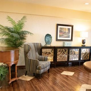 A cozy living room with a piano, armchair, and decorative elements.