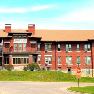 An elegant historic red brick building showcasing classic architectural elements against a clear blue sky.