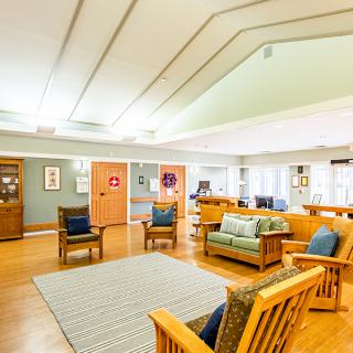 A bright and cozy living room featuring wooden furniture and a seating area.