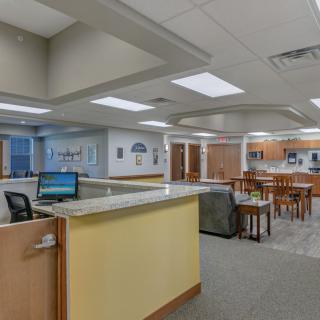 A spacious and modern reception area with a front desk, seating, and ample lighting.