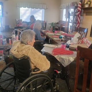 A cozy gathering at a care facility, with residents engaged in various activities.