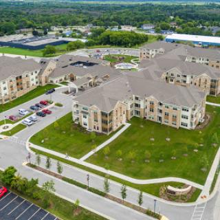 Aerial view of a modern apartment complex with landscaped grounds and parking areas.