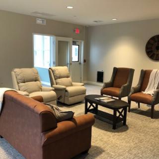 A cozy living room with comfortable seating arrangements, including sofas and chairs around a coffee table.