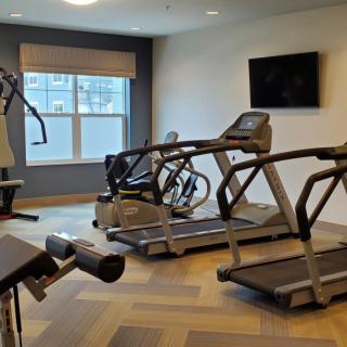 A modern gym with treadmills, a stationary bike, and other exercise equipment.