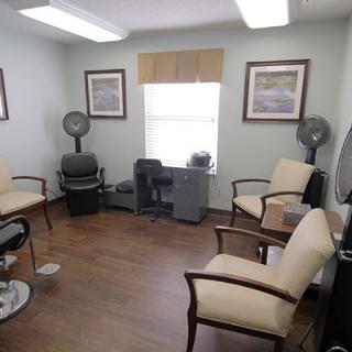 A cozy waiting room with comfortable chairs and decorative paintings on the walls.