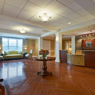 A spacious and well-lit hotel lobby with comfortable seating and a reception desk.
