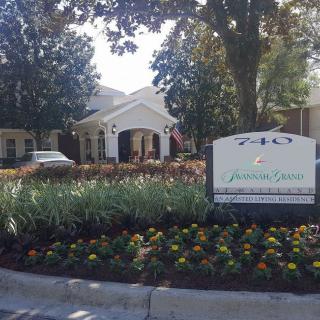 Entrance to a building with surrounding landscaped gardens.