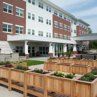 A modern apartment building with wooden planters in the foreground.